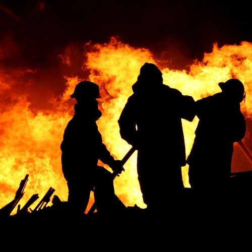 Firefighter silhouetted against training flames